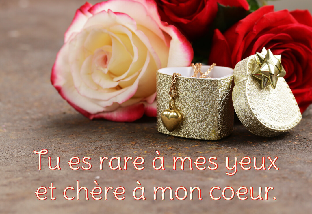 Une composition romantique montrant une boîte cadeau dorée en forme de cœur avec un collier, posée à côté de roses rouges et bicolores.