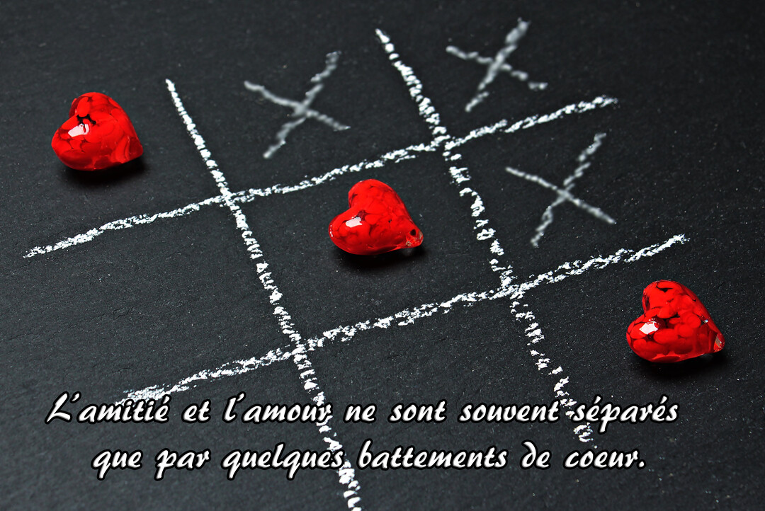 Sur un fond noir d'ardoise, un jeu de morpion dessiné à la craie blanche met en scène trois cœurs rouges vifs et brillants.