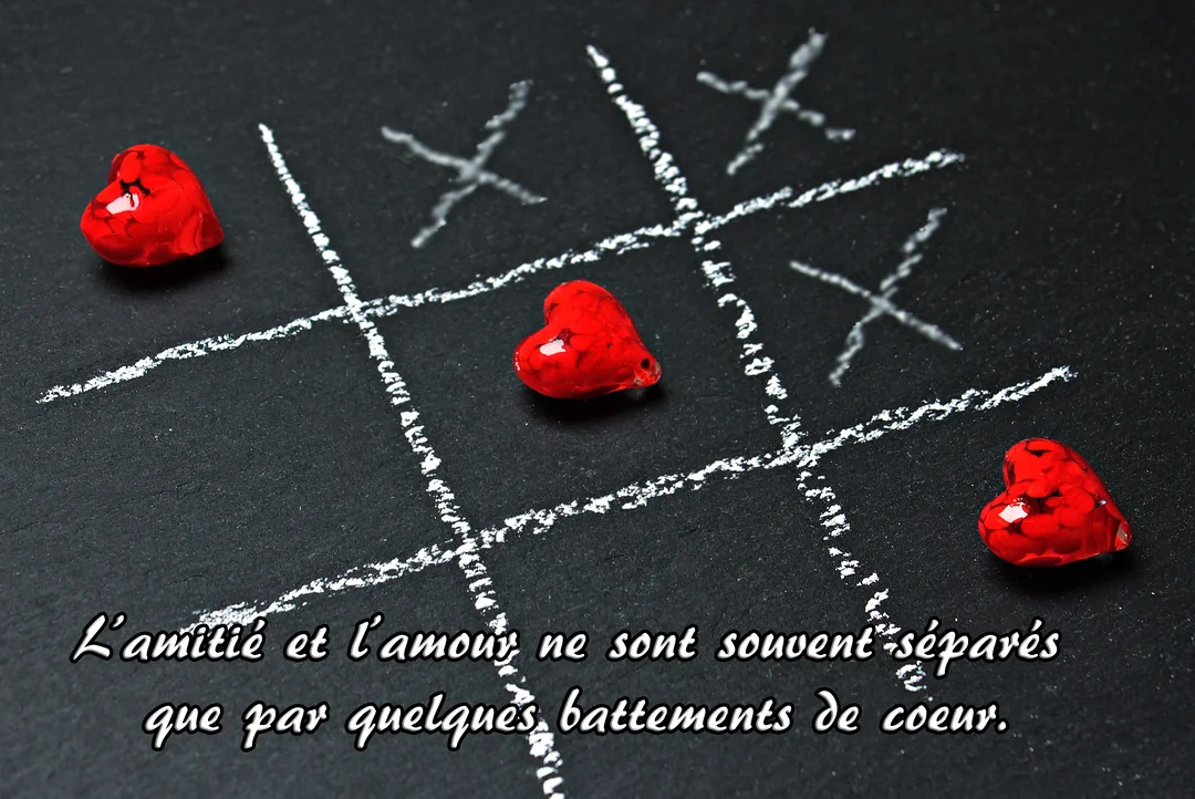 Sur un fond noir d'ardoise, un jeu de morpion dessiné à la craie blanche met en scène trois cœurs rouges vifs et brillants.