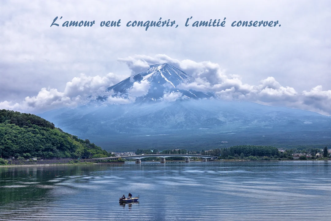 Un majestueux paysage de lac et de montagne sous un ciel nuageux, avec un bateau et la citation 'L'amour veut conquérir, l'amitié conserver'.
