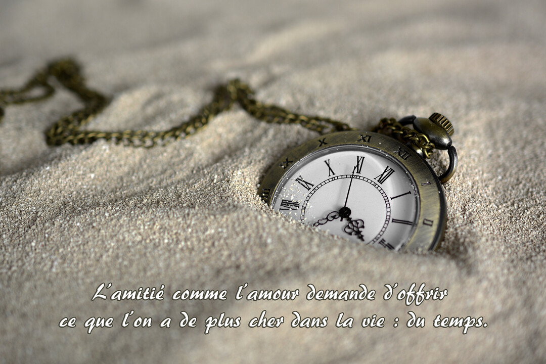Photographie d'une montre à gousset de style ancien, à demi enfouie dans du sable fin, symbolisant le temps qui passe.