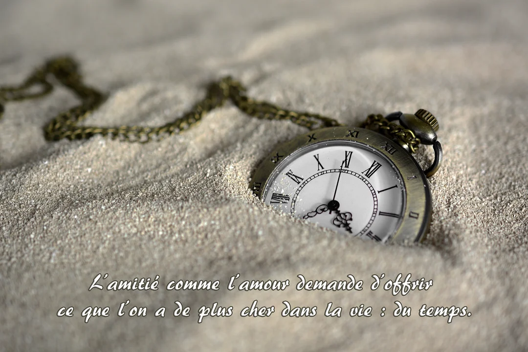 Photographie d'une montre à gousset de style ancien, à demi enfouie dans du sable fin, symbolisant le temps qui passe.