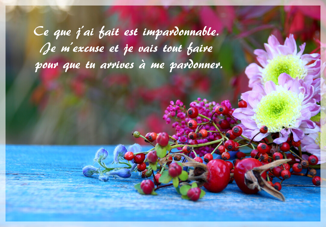 Sur une table en bois bleu, un bouquet de fleurs d'automne, chrysanthèmes et baies, accompagne un texte de demande de pardon manuscrit.