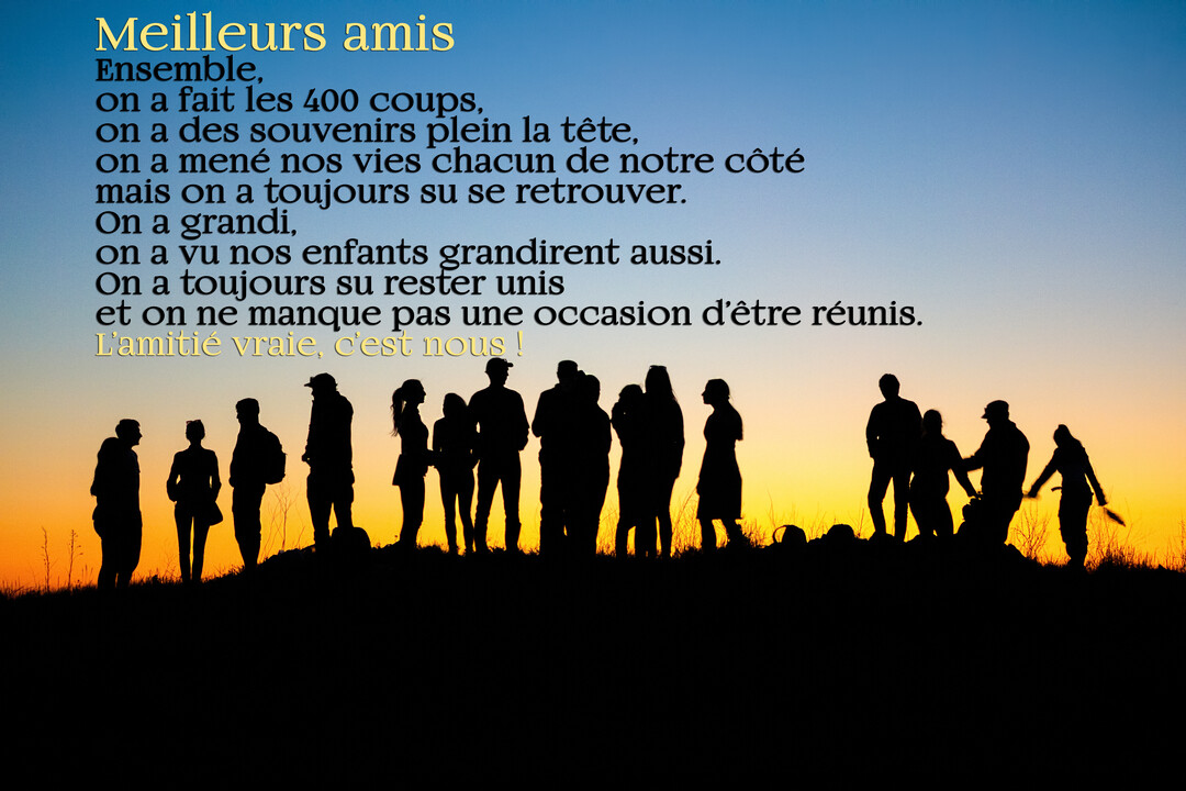 Les silhouettes noires d'un groupe d'amis se tiennent sur une colline face à un magnifique coucher de soleil orangé et bleu.