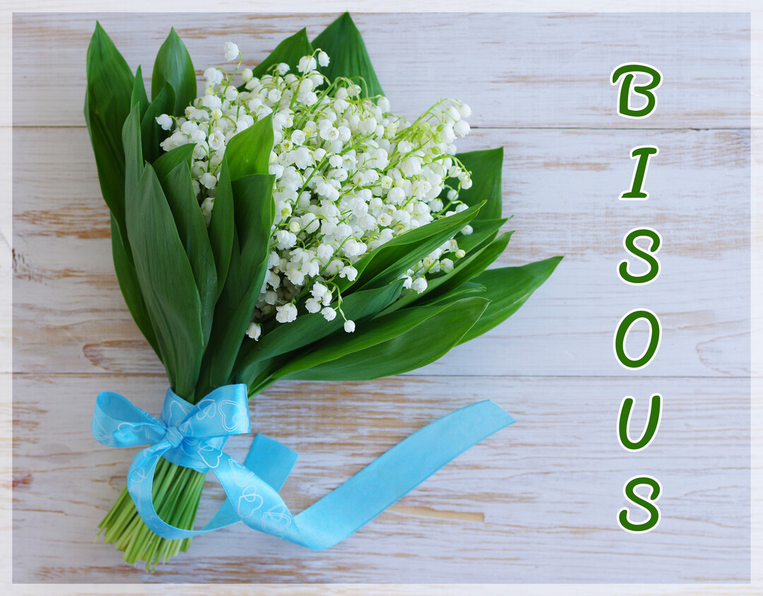 Un bouquet de muguet aux clochettes blanches et feuilles vertes, noué d'un ruban bleu, est posé sur un fond en bois clair.