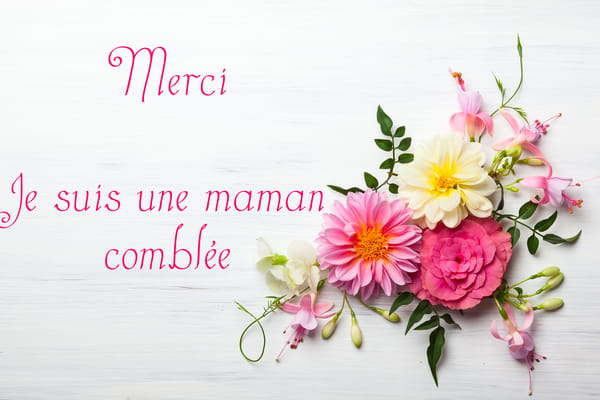 Carte de Fête des Mères avec le texte 'Merci, je suis une maman comblée' et un délicat bouquet de fleurs roses et blanches sur fond blanc.