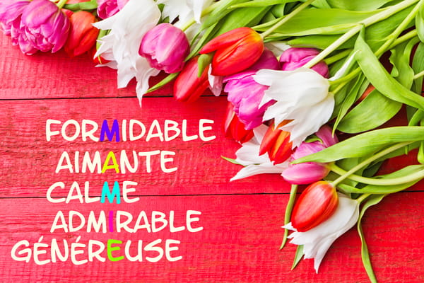 Carte pour la Fête des Grands-mères avec un bouquet de tulipes sur fond rouge et un acrostiche de qualités formant le mot 'Mamie'.