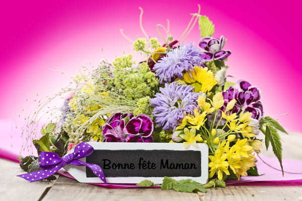Carte de Fête des Mères avec un bouquet de fleurs des champs colorées et une étiquette ardoise sur laquelle est écrit "Bonne fête Maman".