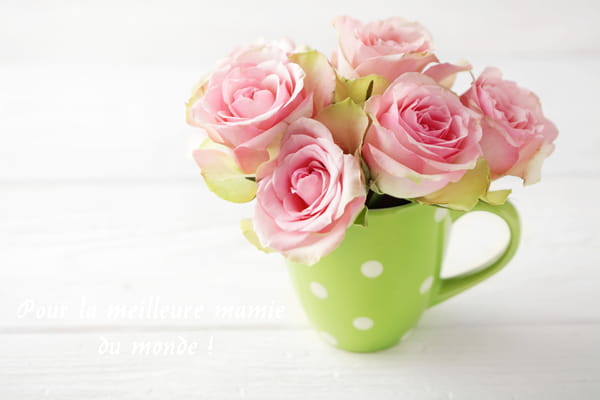 Carte pour la Fête des Grands-mères montrant un bouquet de roses roses dans une tasse verte à pois blancs, avec le message "Pour la meilleure mamie du monde !"
