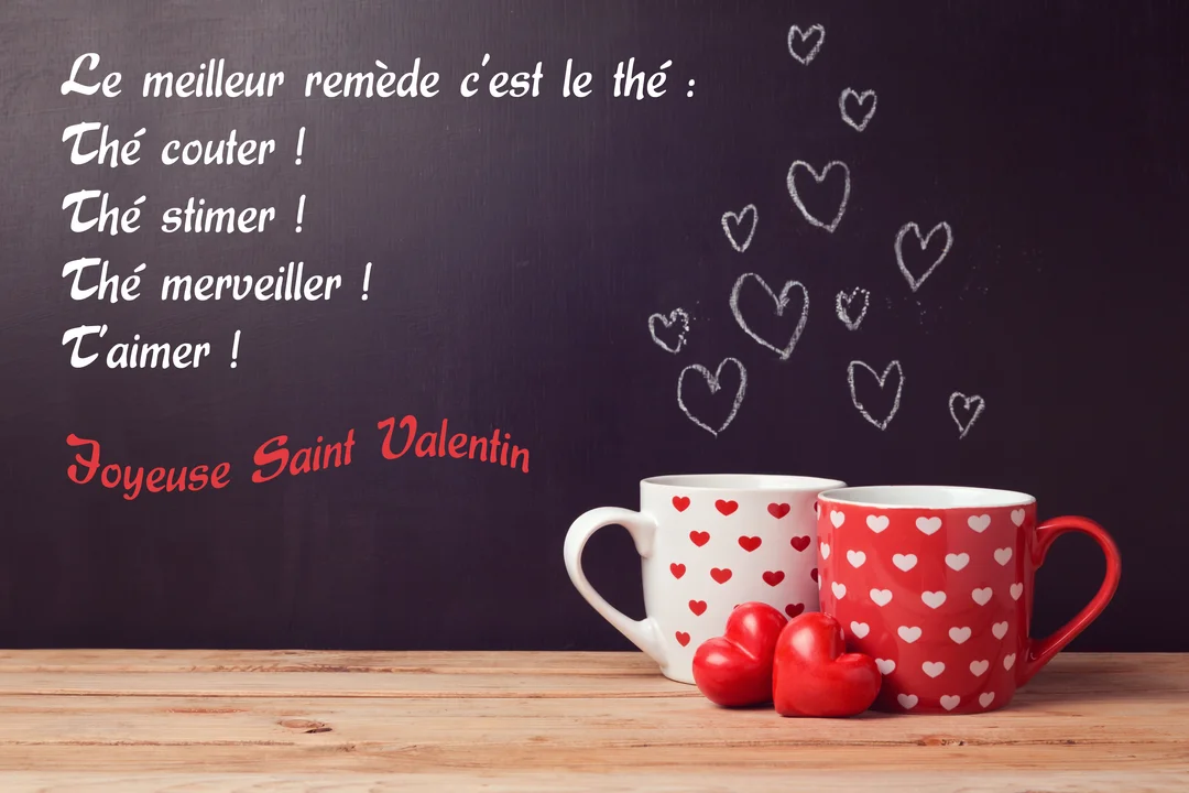 Sur une table en bois, deux mugs à motifs de cœurs sont posés devant un tableau noir où est écrit un poème d'amour humoristique.