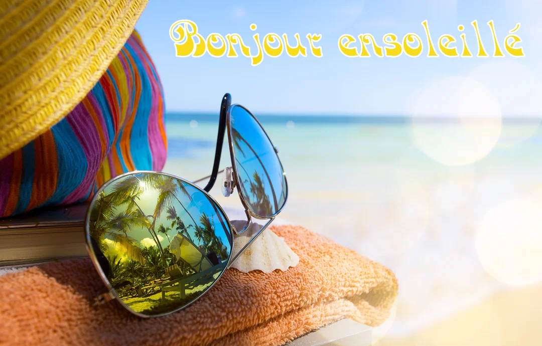 Scène de plage en gros plan avec des lunettes de soleil, un chapeau et une serviette, avec la mer en arrière-plan flou.