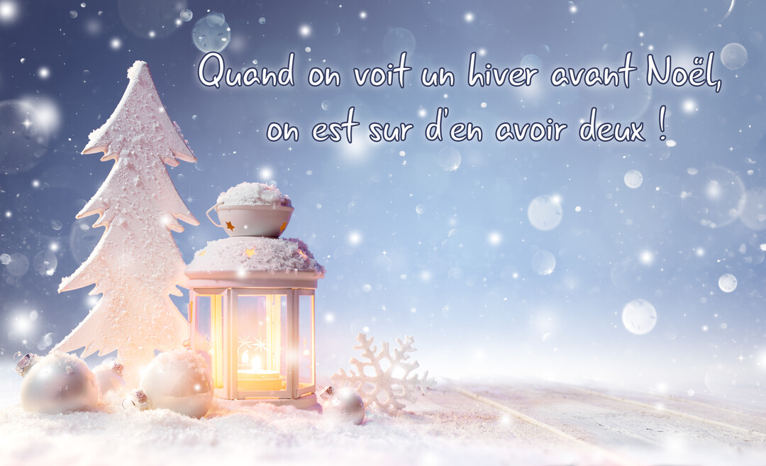 Une composition hivernale de nuit avec une lanterne allumée, un sapin blanc stylisé et des décorations de Noël posés sur la neige.