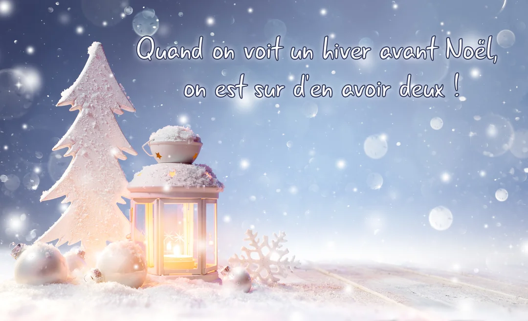 Une composition hivernale de nuit avec une lanterne allumée, un sapin blanc stylisé et des décorations de Noël posés sur la neige.