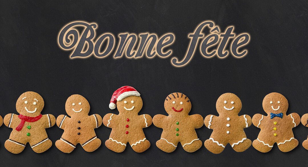 Une rangée de bonshommes souriants en pain d'épices est alignée sous le texte lumineux 'Bonne fête' sur un fond sombre de type ardoise.