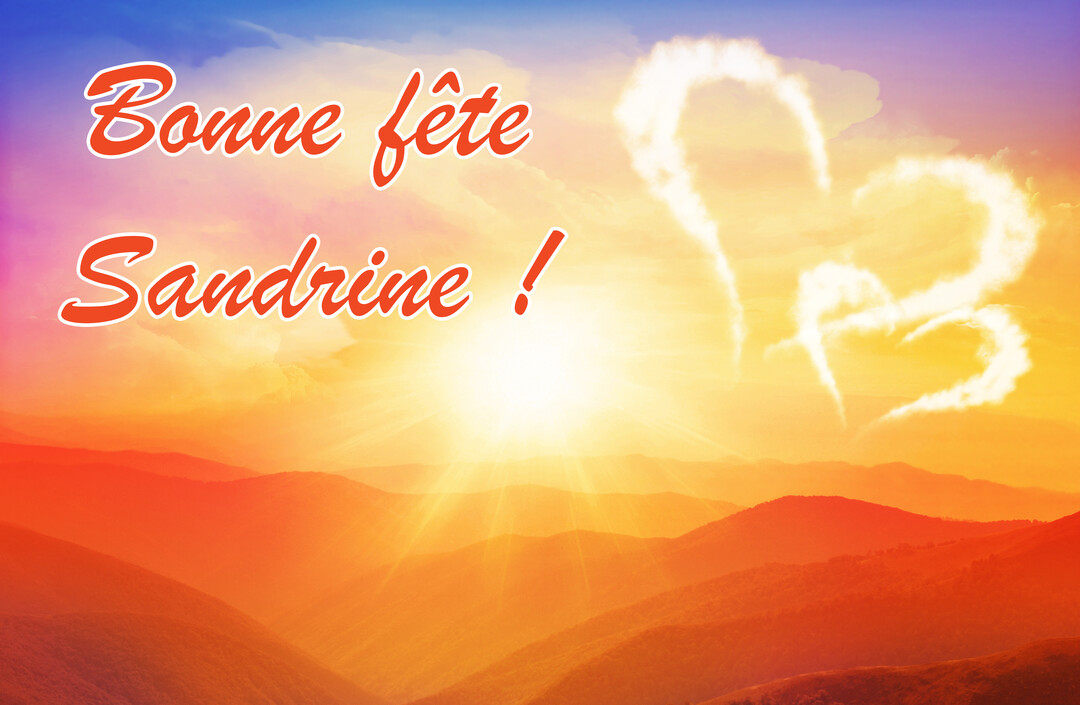 Un paysage montagneux baigné dans la lumière d'un coucher de soleil, avec deux cœurs formés par des nuages et un texte souhaitant 'Bonne fête Sandrine'.
