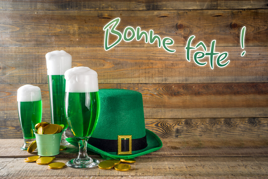 Une composition festive pour la Saint-Patrick montrant trois verres de bière verte, un chapeau de farfadet et des pièces d'or scintillantes.