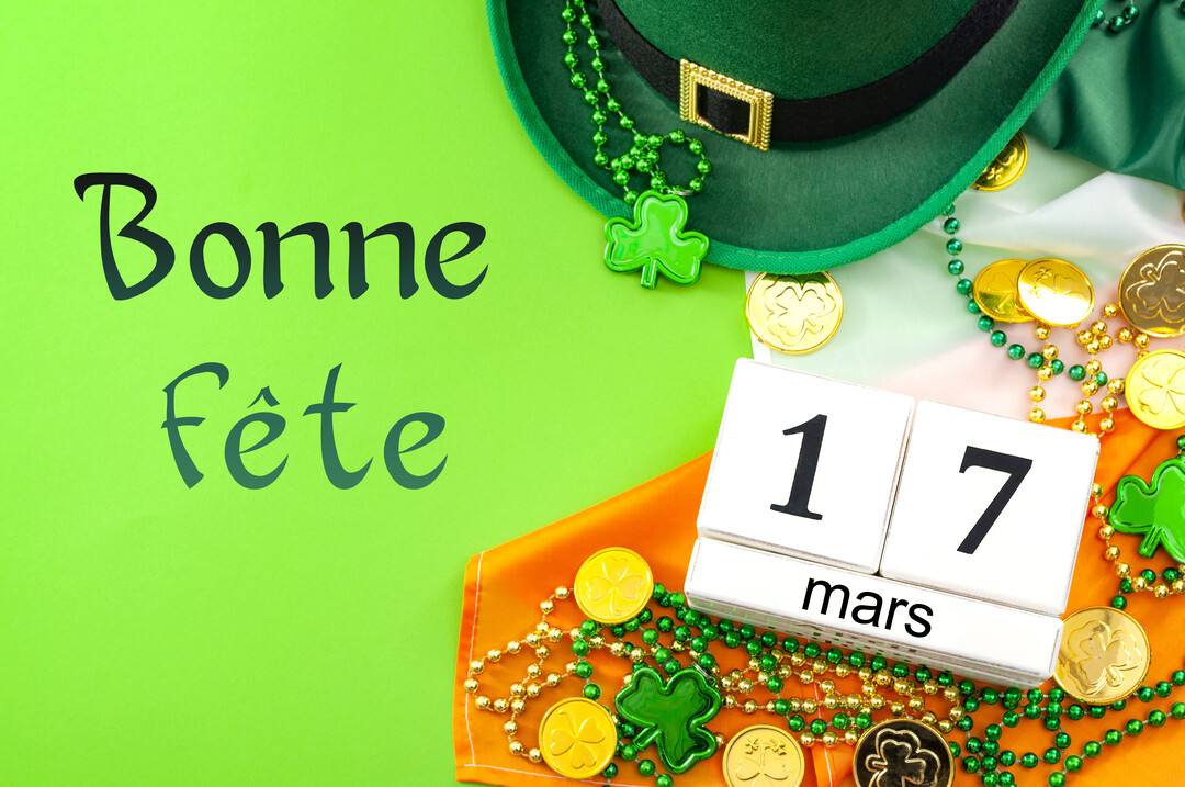 Une composition festive pour la Saint-Patrick avec un chapeau vert, des trèfles, des pièces d'or et la date du 17 mars.