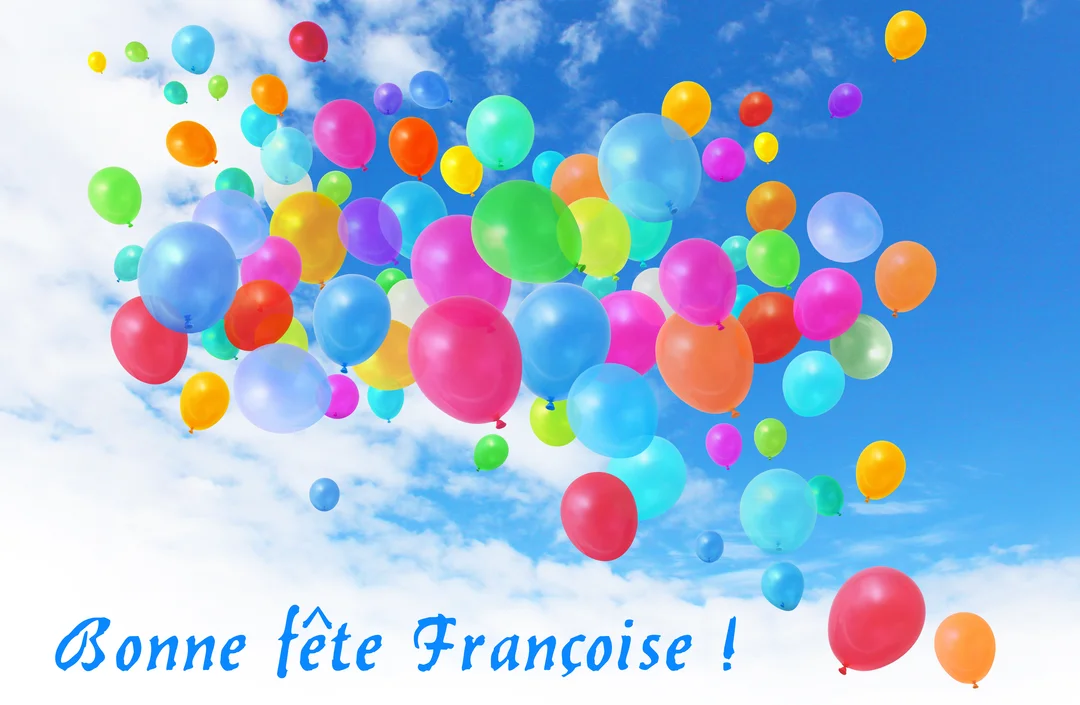 Des dizaines de ballons de toutes les couleurs flottent joyeusement dans un ciel bleu parsemé de nuages blancs, avec un message de fête.