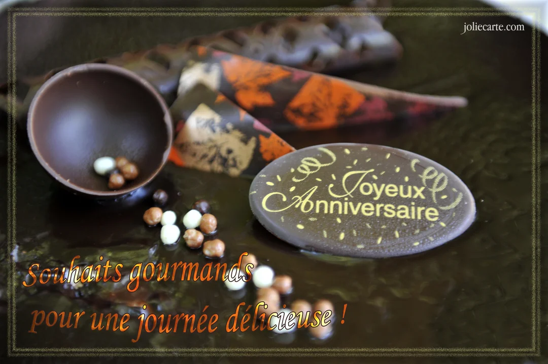 Gros plan sur un gâteau d'anniversaire orné de décorations et d'une plaque en chocolat où est inscrit en lettres dorées 'Joyeux Anniversaire'.