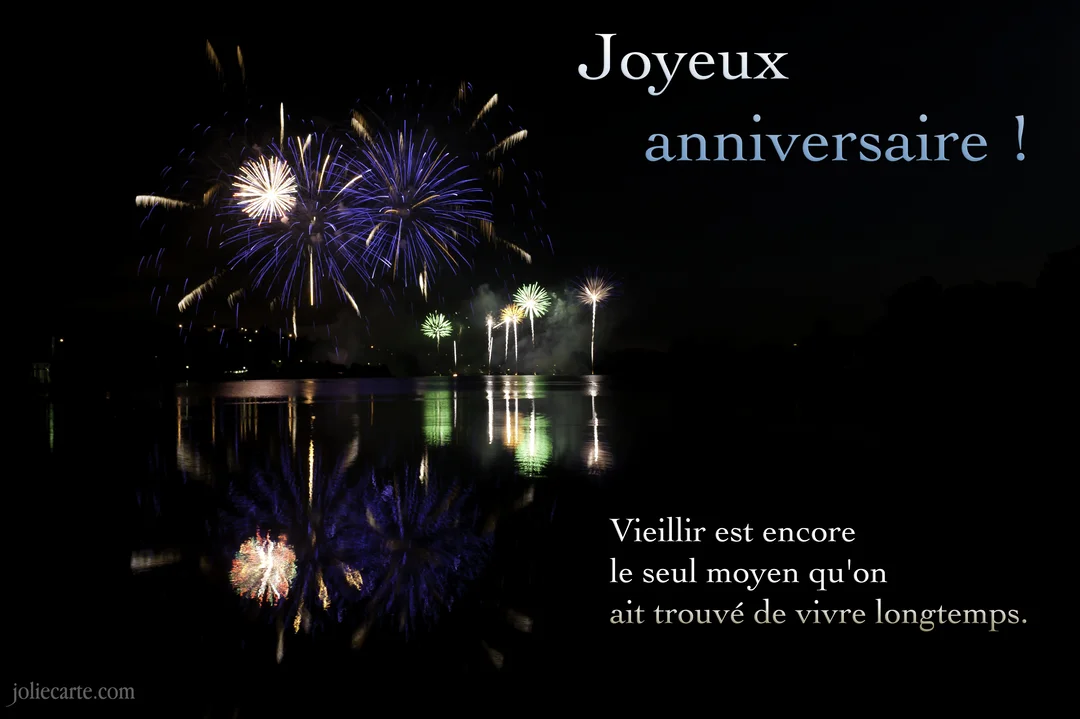 Une photo nocturne de feux d'artifice colorés explosant au-dessus d'un lac, avec leurs reflets scintillants dans l'eau et un texte de vœux.