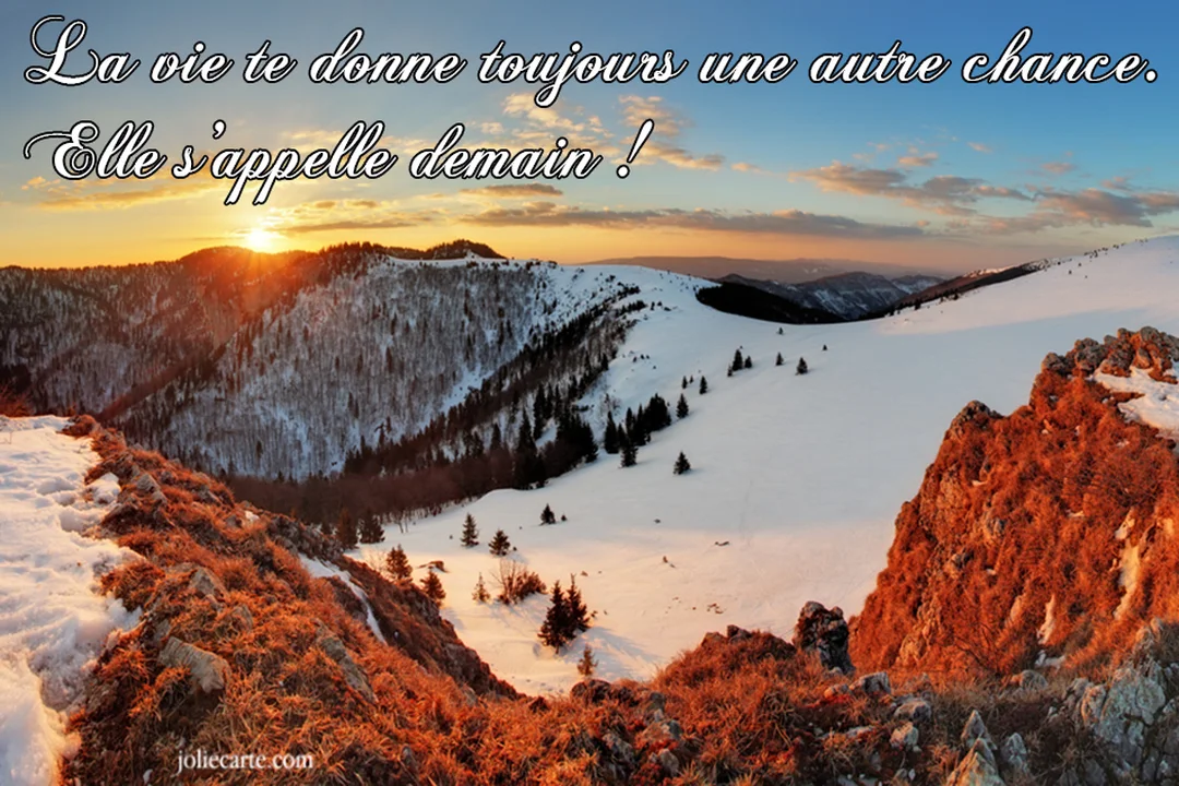 Un soleil éclatant se lève sur une chaîne de montagnes couvertes de neige, illuminant le paysage d'une lueur chaude et dorée.