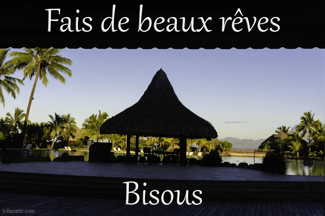 Cette carte présente la photographie d'un paysage tropical au crépuscule, avec une paillote en chaume au premier plan, près d'un lagon.