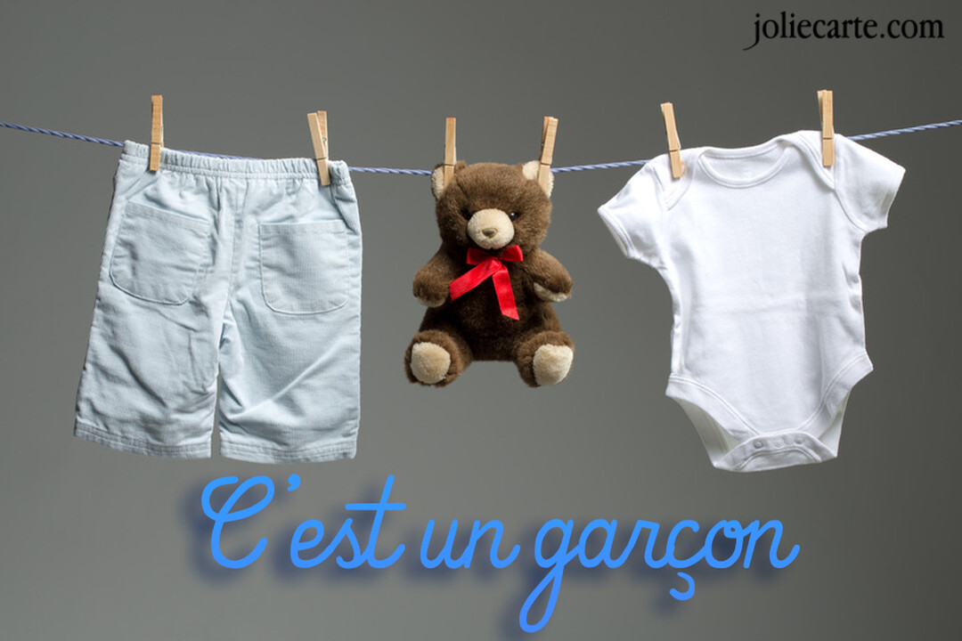 Un short bleu en velours, un petit ours en peluche et un body de bébé blanc sont accrochés avec des pinces à linge sur un fil.