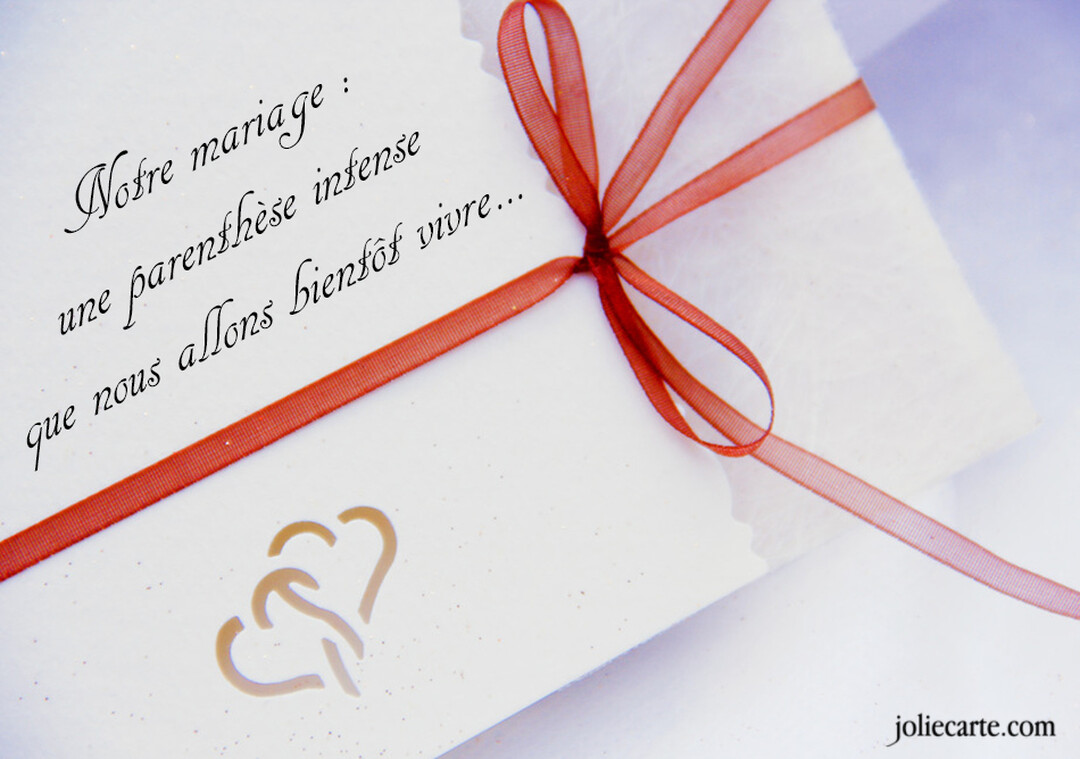 Un faire-part de mariage blanc est orné d'un fin ruban rouge et de deux cœurs dorés, avec un texte calligraphié annonçant l'événement.