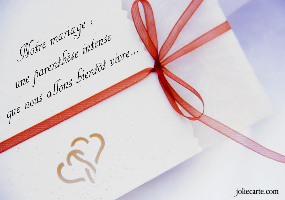 Un faire-part de mariage blanc est orné d'un fin ruban rouge et de deux cœurs dorés, avec un texte calligraphié annonçant l'événement.