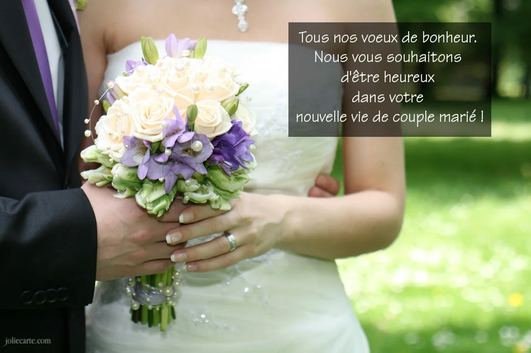 Un couple de mariés vu en gros plan, leurs mains jointes sur un bouquet de mariage composé de roses crème et de fleurs violettes.