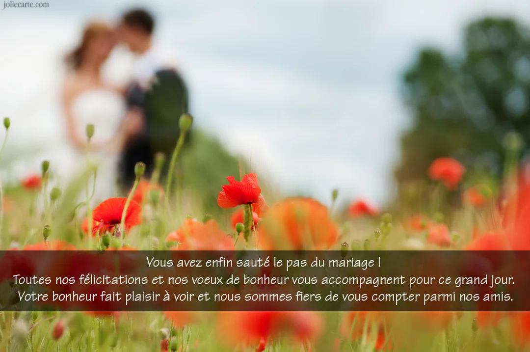 Un couple de mariés s'embrasse dans un champ, avec des coquelicots rouges vifs au premier plan et un arrière-plan flouté et verdoyant.