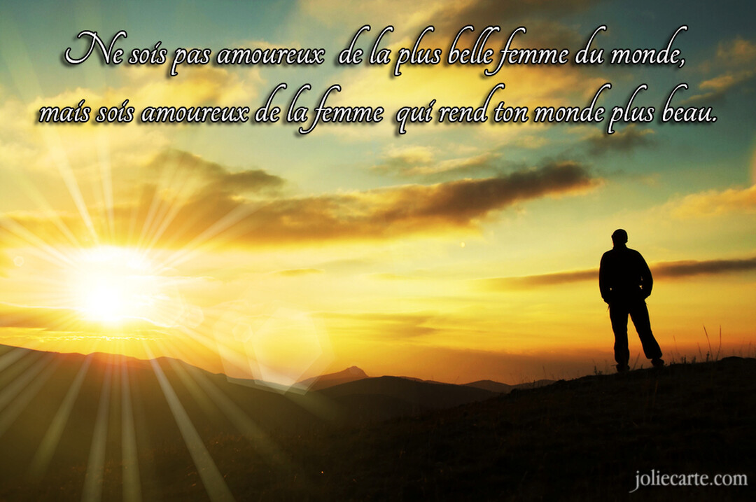 Une silhouette d'homme se tient sur une colline, contemplant un soleil éclatant qui se couche derrière les montagnes, avec une citation d'amour superposée.