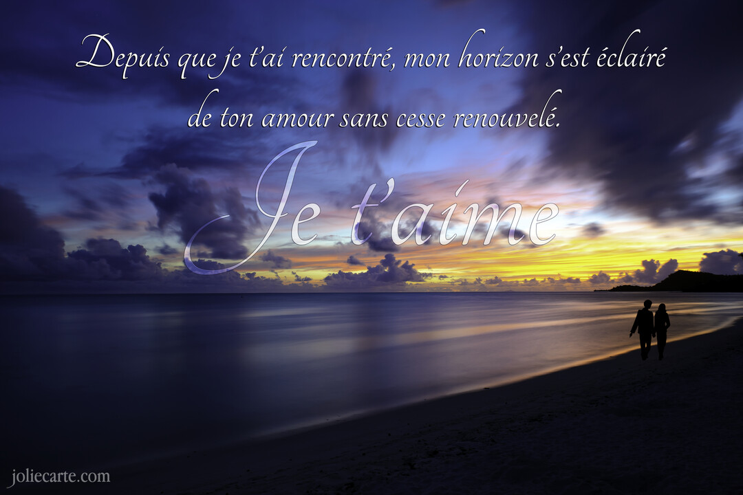 Un couple se promène main dans la main sur une plage de sable fin, sous un ciel de crépuscule aux teintes orangées et violettes.