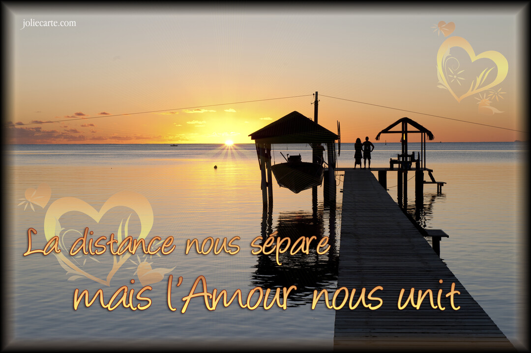 Un couple se tient en silhouette sur un ponton en bois, contemplant un coucher de soleil sur une mer calme et paisible.