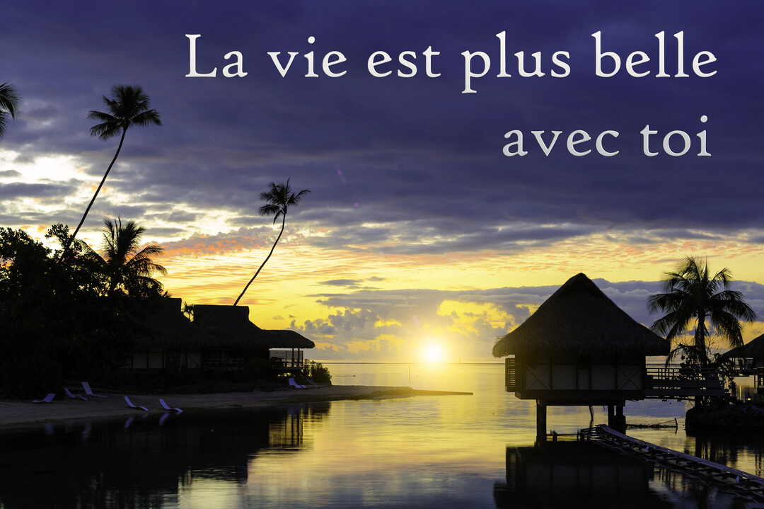 Un paysage paradisiaque au crépuscule, avec des bungalows sur pilotis et des palmiers se reflétant sur une mer calme et dorée.
