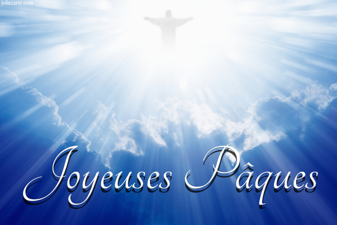 Dans un ciel bleu nuageux, la silhouette lumineuse de Jésus-Christ s'élève au-dessus du texte blanc calligraphié 'Joyeuses Pâques'.