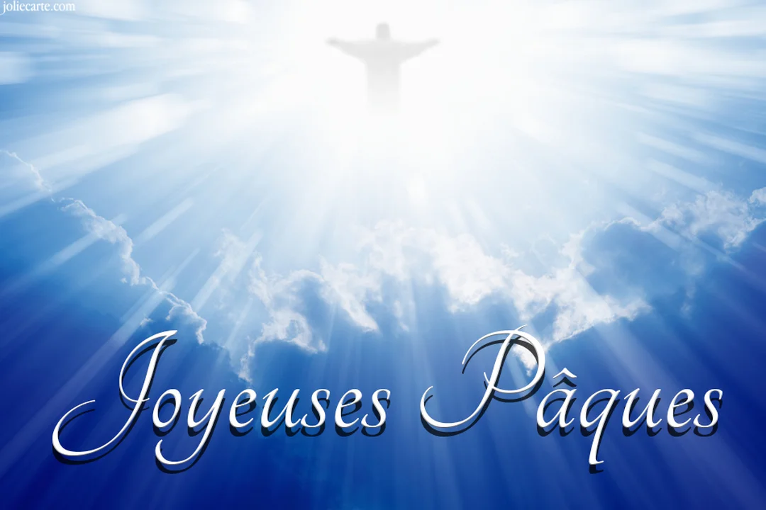 Dans un ciel bleu nuageux, la silhouette lumineuse de Jésus-Christ s'élève au-dessus du texte blanc calligraphié 'Joyeuses Pâques'.