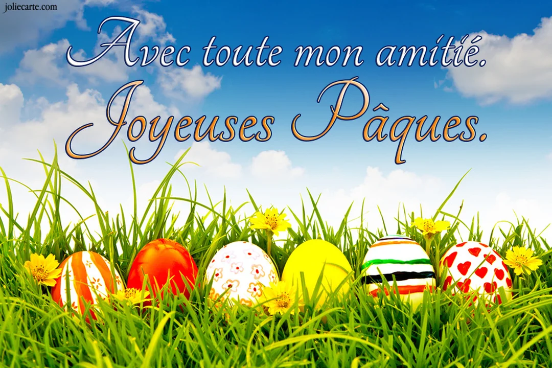 Plusieurs œufs de Pâques décorés sont alignés dans l'herbe fraîche et parsemée de petites fleurs jaunes, sous un ciel bleu nuageux.