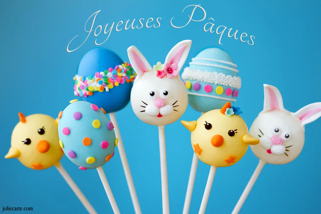 Une collection de sept sucettes 'cake pops' décorées en lapins, poussins et œufs de Pâques, sur un fond bleu uni.