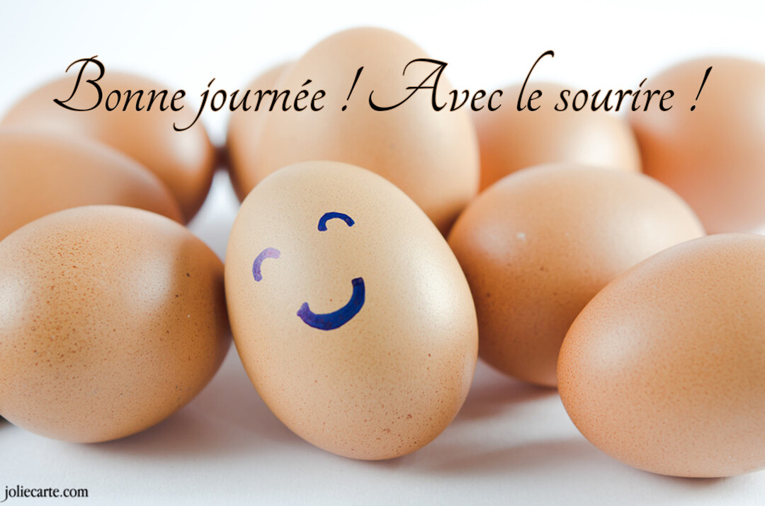 Photographie en gros plan d'un œuf de poule marron sur lequel est dessiné un visage souriant, entouré de plusieurs autres œufs.