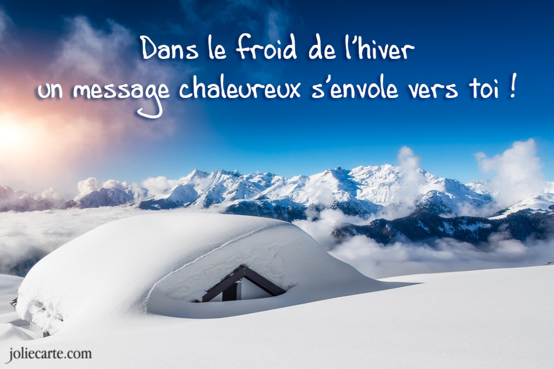 Un chalet est entièrement recouvert de neige au premier plan, avec en arrière-plan une chaîne de montagnes enneigées sous un soleil éclatant.