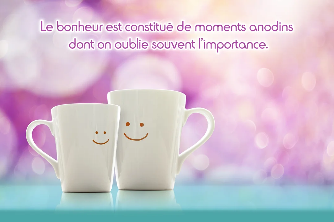 Deux tasses blanches, une grande et une petite avec des smileys dessinés, sont posées sur une surface turquoise devant un fond bokeh rose.
