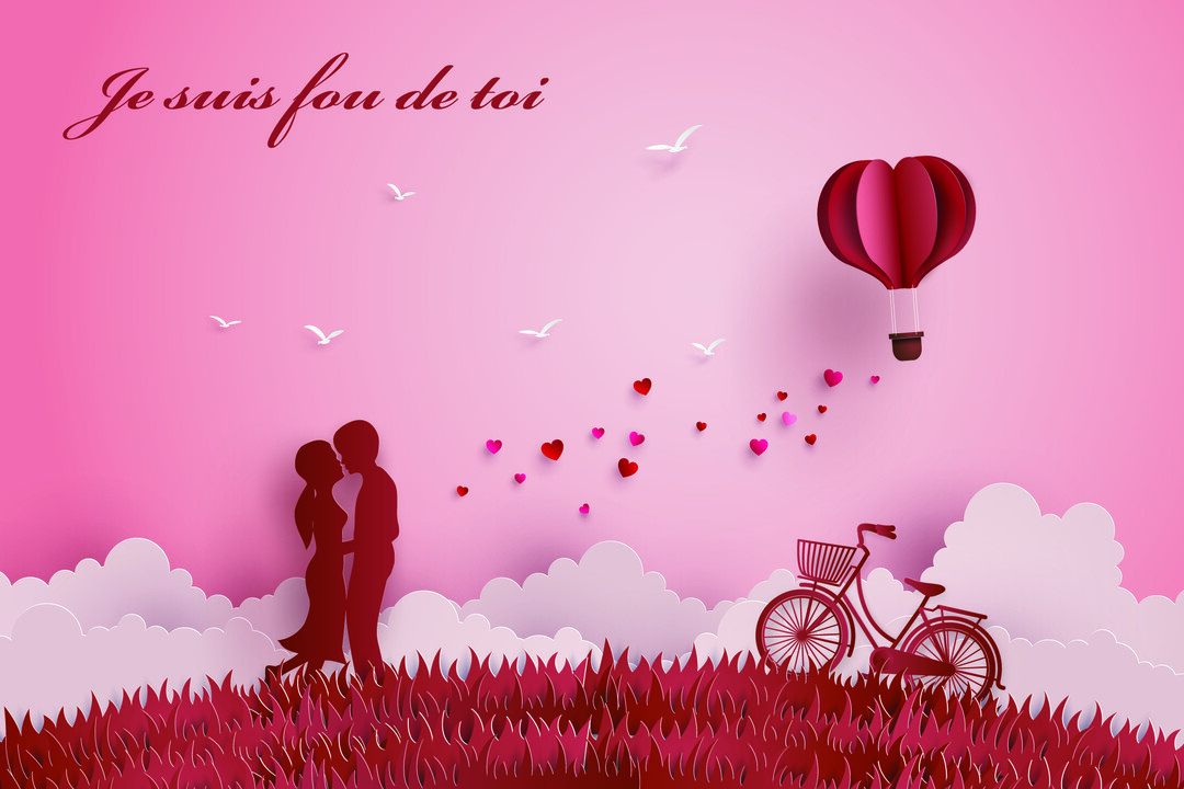 Une illustration de style papier découpé montre la silhouette d'un couple s'embrassant dans un champ, sous un ciel rose avec une montgolfière-cœur.