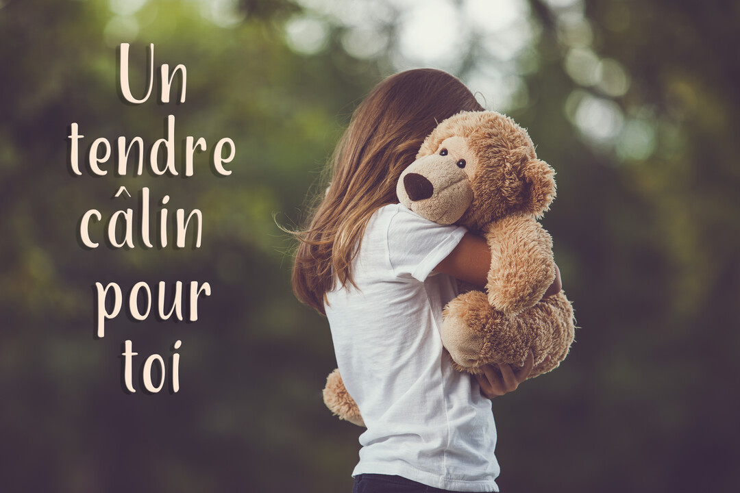 Vue de dos, une jeune fille aux cheveux longs serre dans ses bras un gros ours en peluche, sur un fond vert naturel.