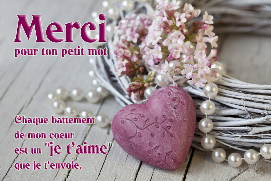 Une composition romantique sur un fond en bois blanc, montrant un cœur rose gravé, une couronne de brindilles, des perles et des fleurs.