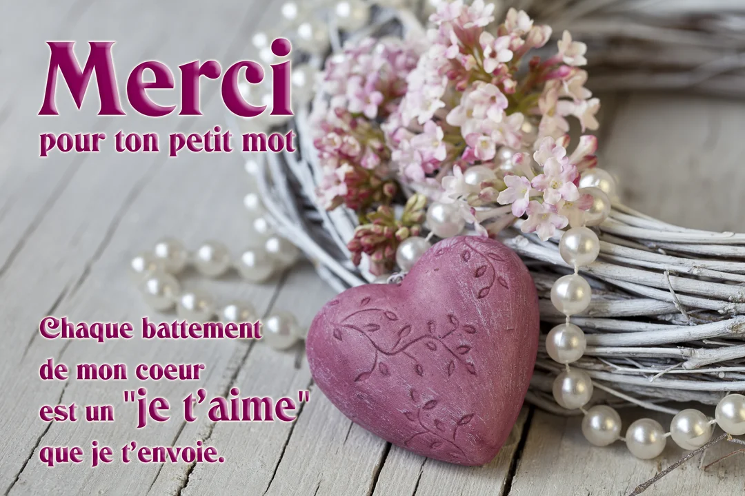 Une composition romantique sur un fond en bois blanc, montrant un cœur rose gravé, une couronne de brindilles, des perles et des fleurs.