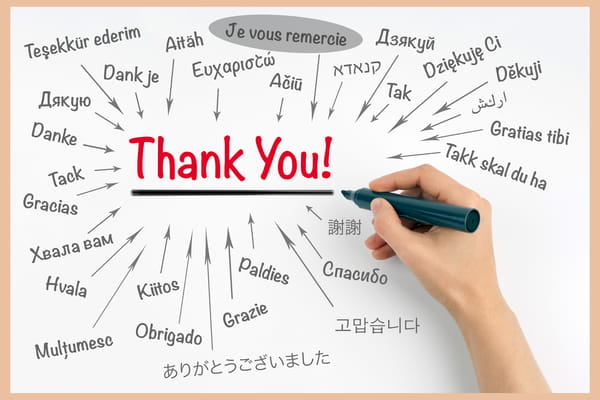 Carte de remerciement conceptuelle montrant le mot 'Thank You' au centre, entouré de ses traductions dans de nombreuses langues sur un fond blanc.