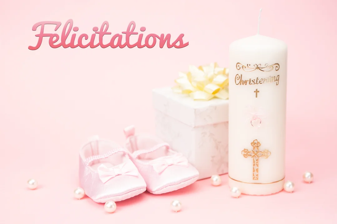 Une composition pour un baptême de fille avec des chaussons de bébé roses, un cierge blanc et un cadeau sur un fond pastel.