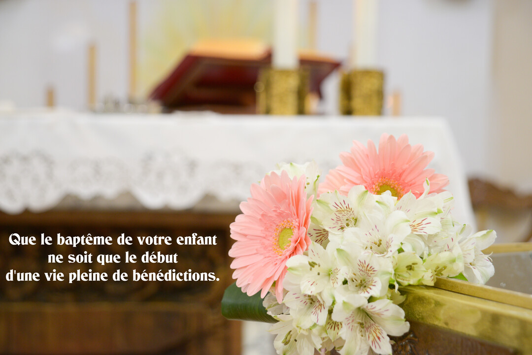 Un bouquet de gerberas roses et d'alstroemerias blancs au premier plan, devant un autel d'église blanc avec des chandeliers dorés en arrière-plan.