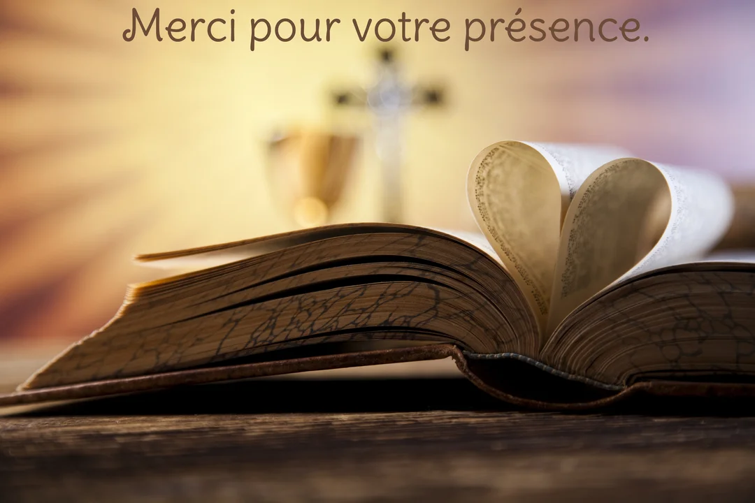 Une bible ancienne est ouverte sur une table en bois, ses pages centrales pliées en forme de cœur, devant un calice et une croix illuminés.